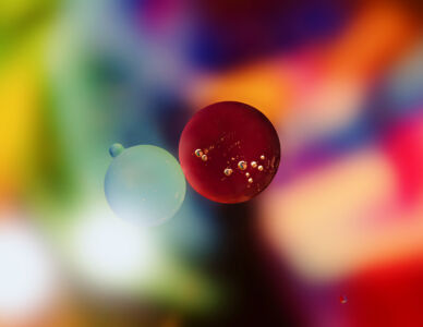 Oil in water in front of a colorful backdrop.